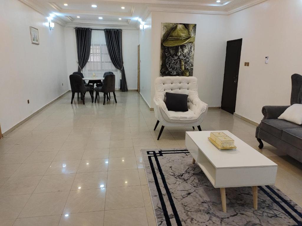 ein Wohnzimmer mit einem Sofa und einem Tisch in der Unterkunft Vintz Apartments in Abuja