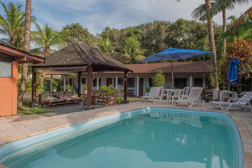 a swimming pool in front of a house at Residencial Solar do Pescador in São Sebastião