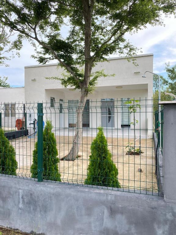 a fence in front of a white building with a tree at Sam Villa in Ulcinj