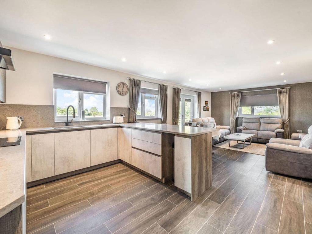 a kitchen and living room with a sink and a couch at Haven Cottage in Blackburn