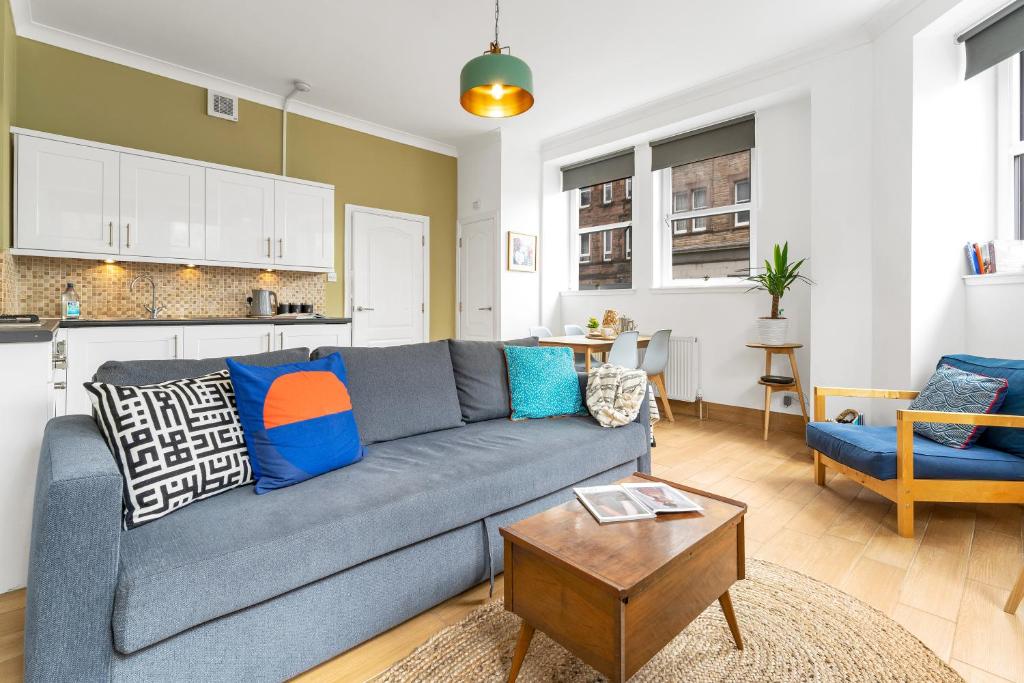 ein Wohnzimmer mit einem grauen Sofa und einem Tisch in der Unterkunft Cozy with Character Lovely Central Apartment in Edinburgh