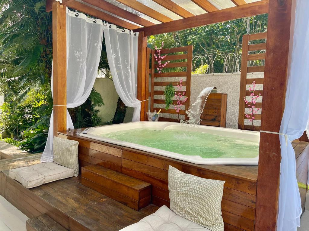 a jacuzzi tub on a deck with at Vila linda com SPA e Piscina a 50 metros da Praia in Guarujá