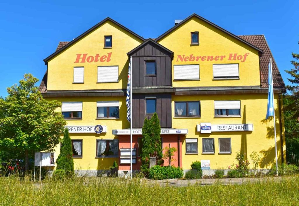 un hotel amarillo con un cartel en la parte delantera en Hotel und Restaurant Nehrener Hof, en Nehren