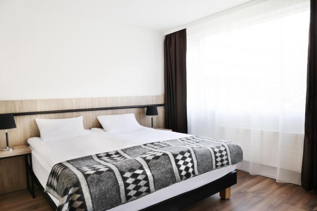 Postel nebo postele na pokoji v ubytování Fosshotel Lind