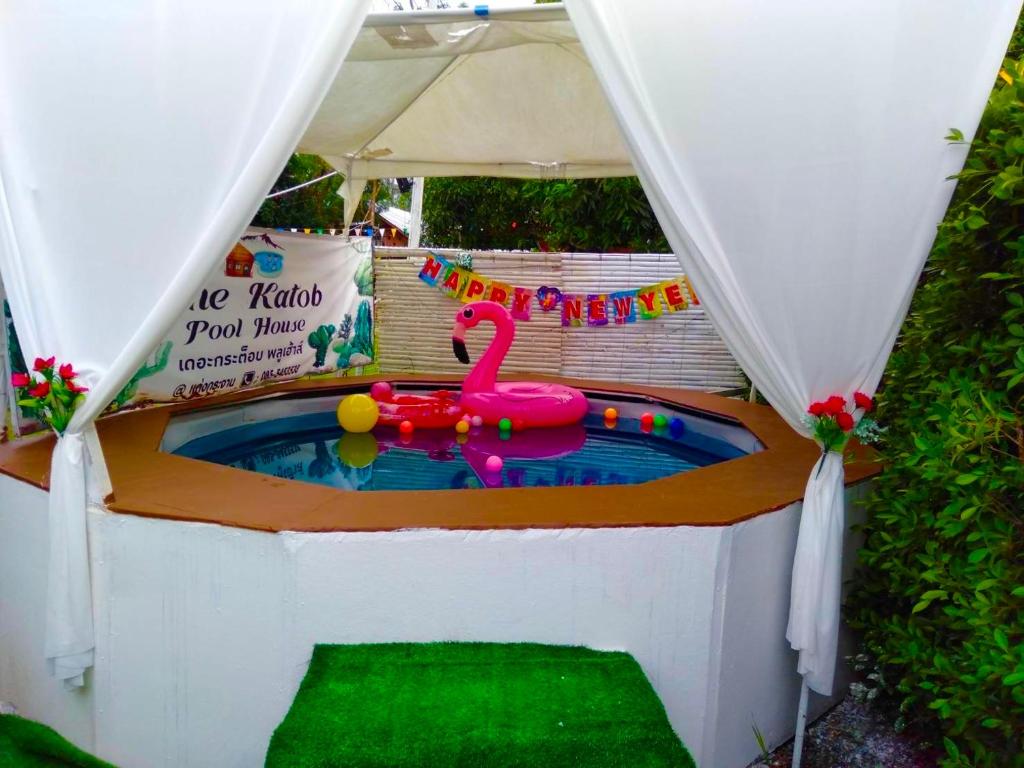 a swimming pool with a pink flamingo in a tent at เดอะกระต็อบพลูเฮ้าส์ By The Mountain Ozoneบ้านโอโซนขุนเขาแก่งกระจาน in Ban Song Phi Nong