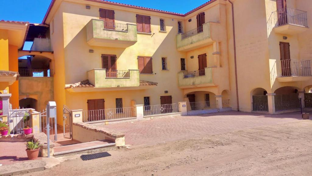 ein großes Apartmenthaus mit Balkon und Innenhof in der Unterkunft Condominio Ulivo in Valledoria