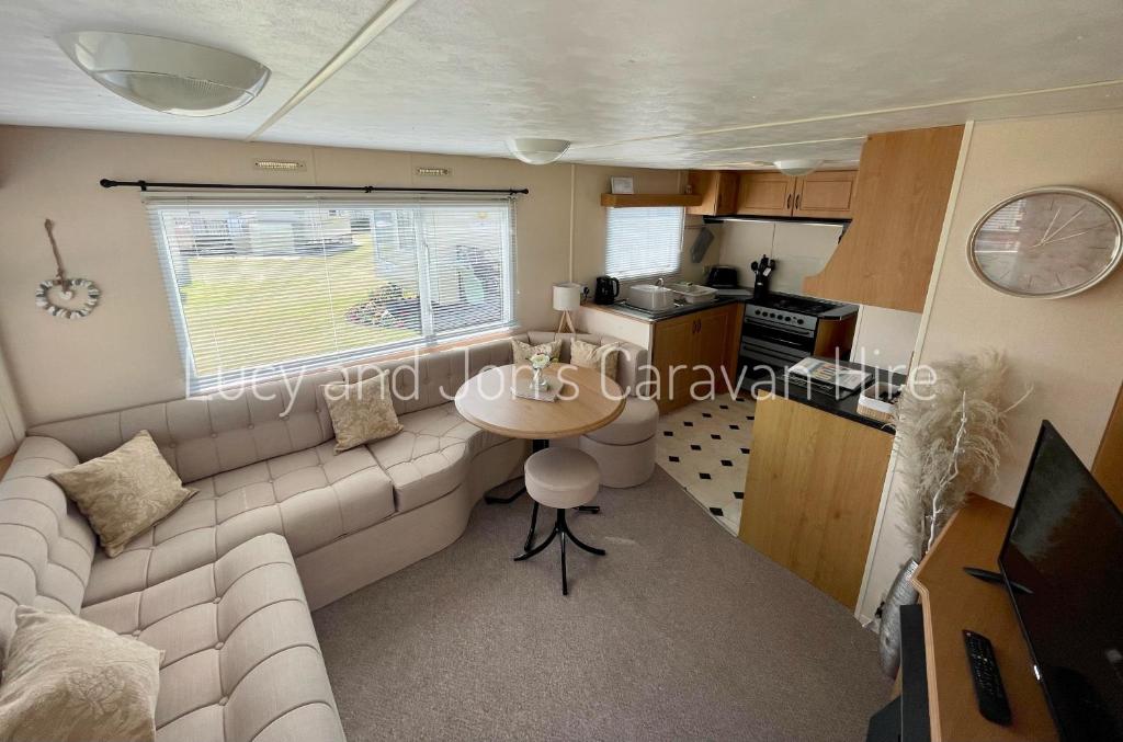 uma sala de estar com um sofá branco e uma mesa em Mablethorpe Seaside Holiday Home em Mablethorpe