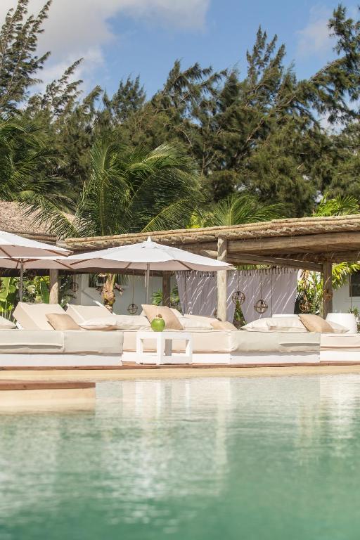 a pool with white chairs and an umbrella and the water at Preabeach Boutique Hotel & SPA in Prea