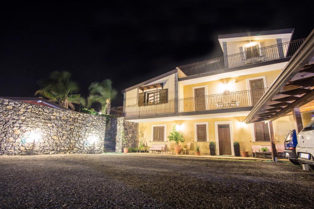 a building with a stone wall next to a street at Villa Gusmano in Piedimonte Etneo