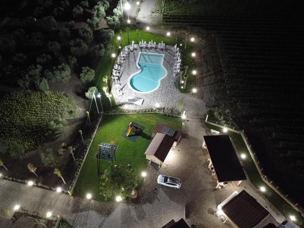 een uitzicht op een zwembad 's nachts met verlichting bij Masseria Spinale Wine Resort in Melfi