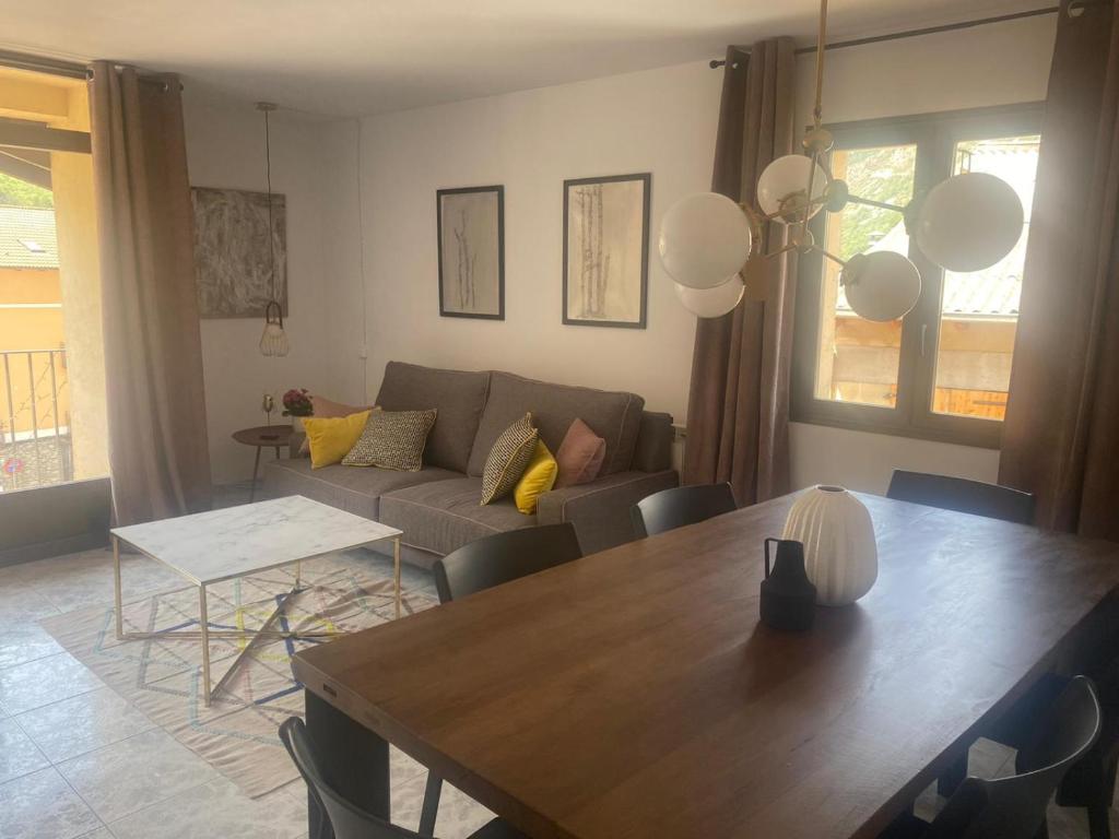 uma sala de estar com uma mesa e um sofá em Apartamento Rincón del Cielo em Castejón de Sos