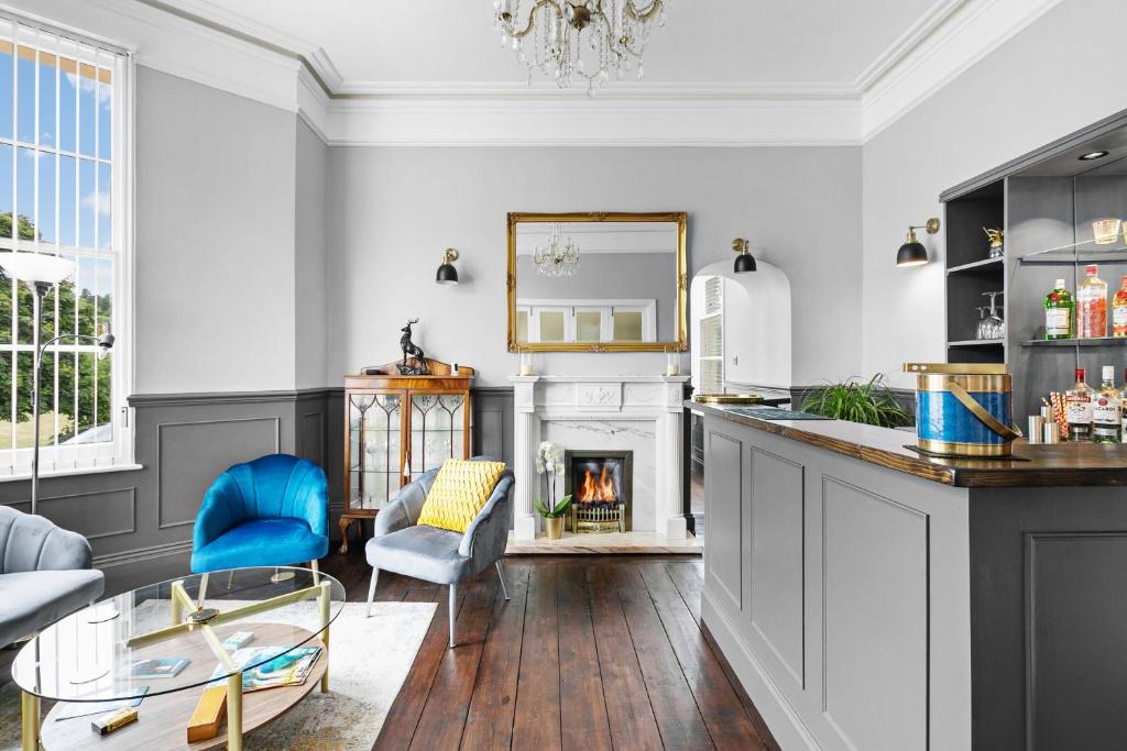 a living room with a fireplace and blue chairs at The Berburry in Torquay