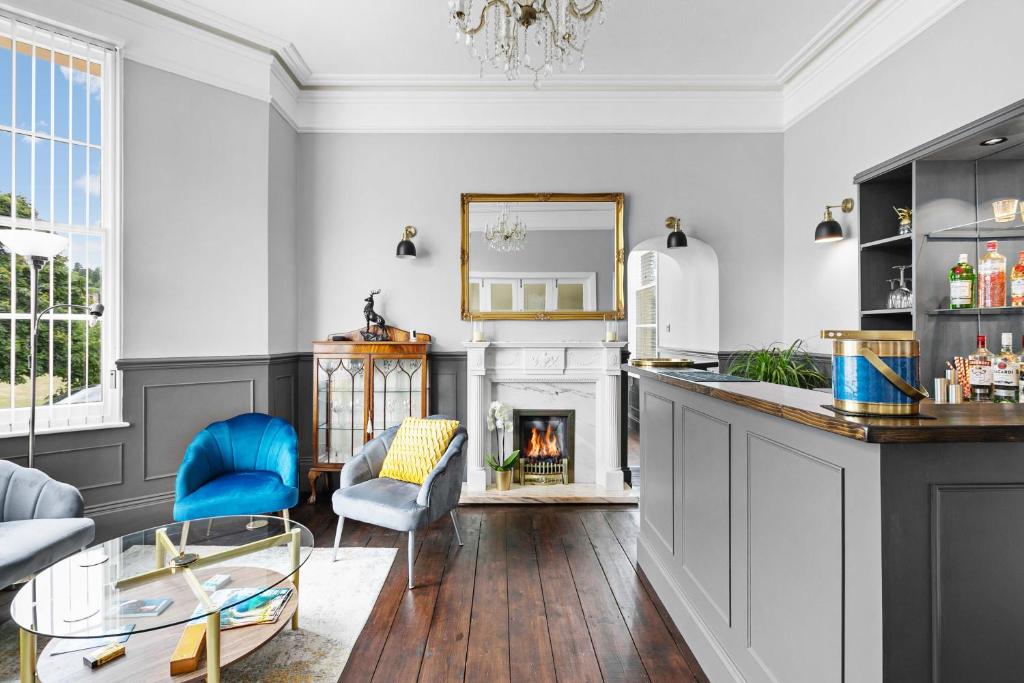 ein Wohnzimmer mit einem Kamin und blauen Stühlen in der Unterkunft The Berburry in Torquay