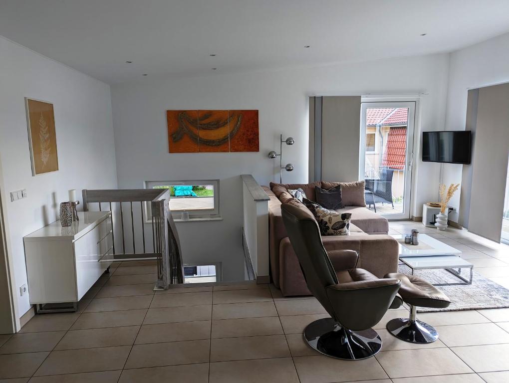 ein Wohnzimmer mit einer Couch und einem Sessel in der Unterkunft Ferienwohnungen direkt am See bei den Kaiserbädern in Bansin