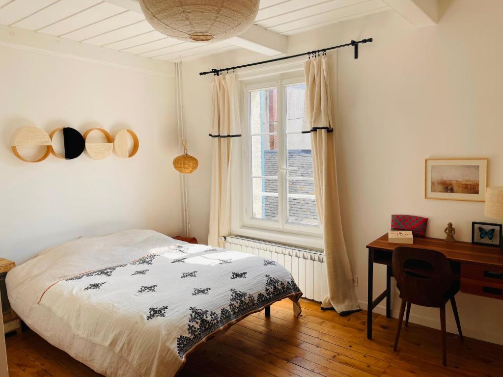 Schlafzimmer mit einem Bett, einem Schreibtisch und einem Fenster in der Unterkunft Charmante maison de pêcheur à Trouville sur Mer in Trouville-sur-Mer