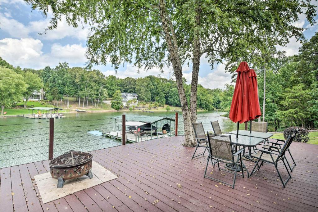 a patio with a table and chairs and an umbrella at Waterfront Getaway with Fire Pit and Game Room! in Iva