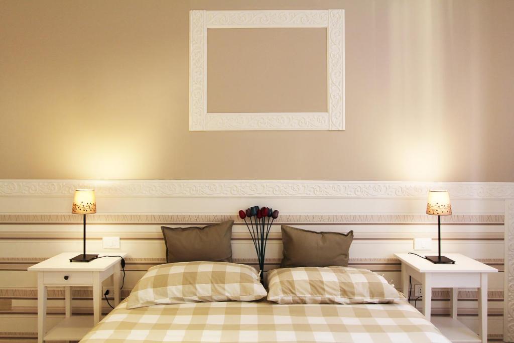 波隆那的住宿－博洛尼亞多米瑞住宿加早餐旅館，一间卧室设有两张床和两张带台灯的桌子。
