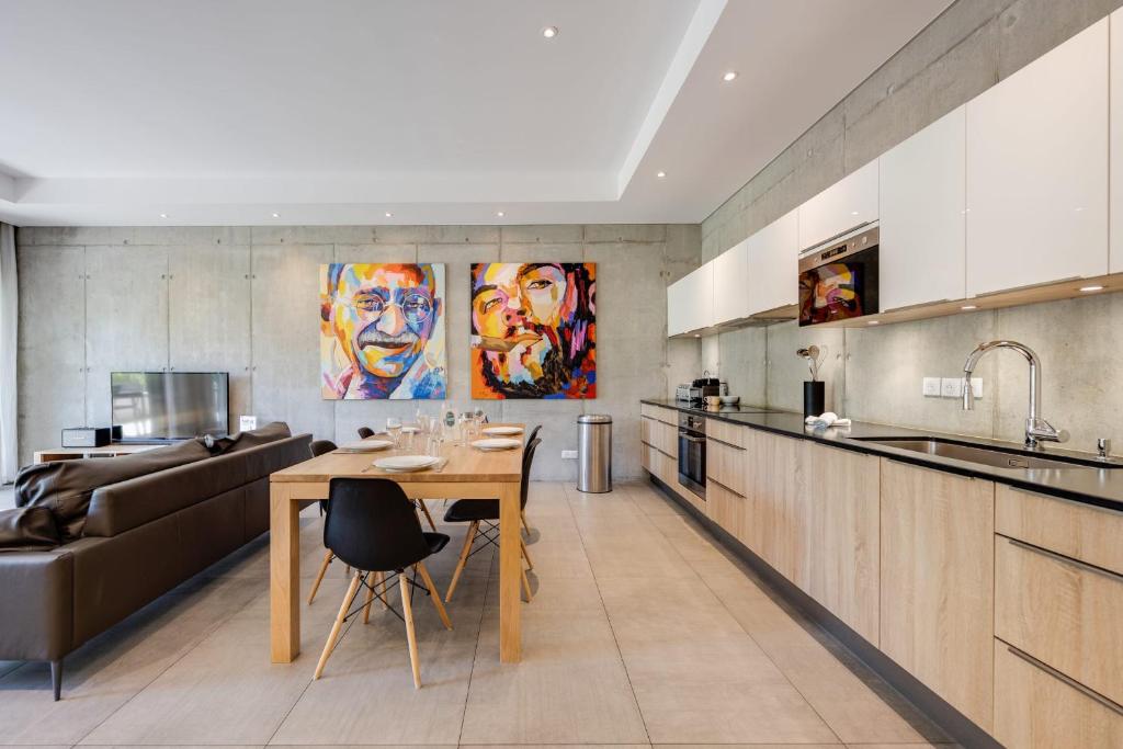 a kitchen and living room with a table and a couch at Le Kube - Appartements de Prestige au centre d'Annecy in Annecy