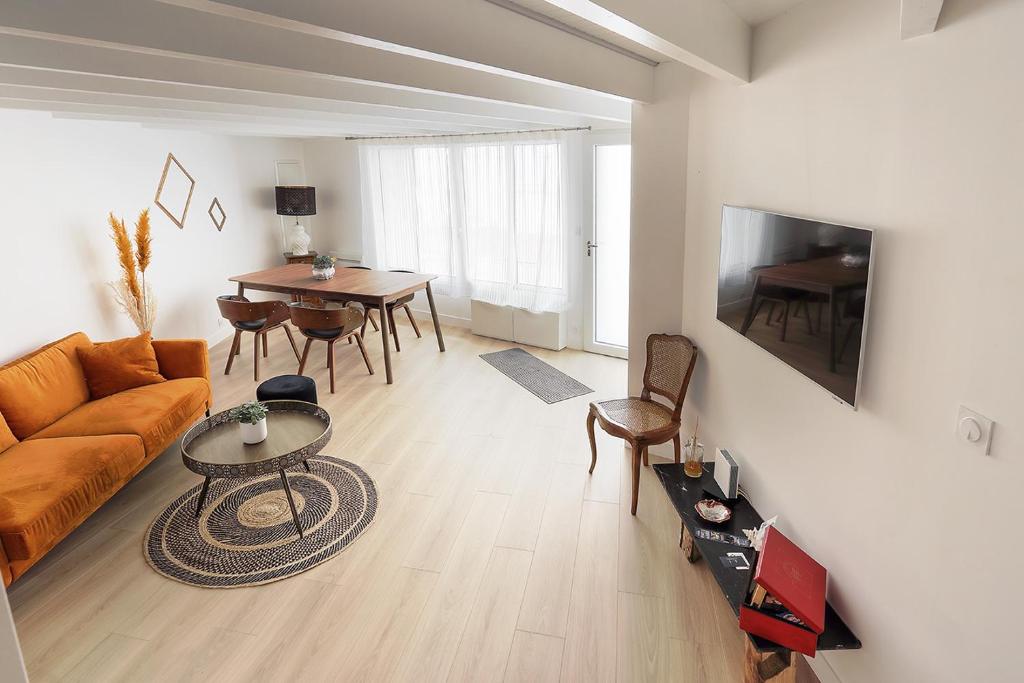 a living room with a couch and a table at La Galerie Pornic - Maison Cedre in Pornic