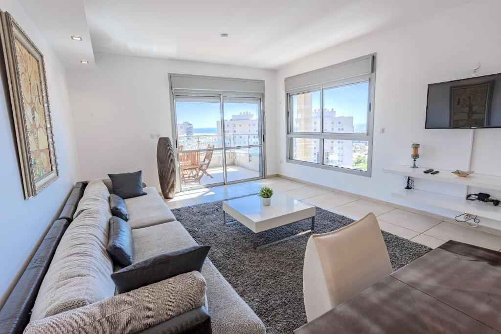 sala de estar con sofá y mesa en Luxury Marina 4BR apartment by Airsuite en Ashdod