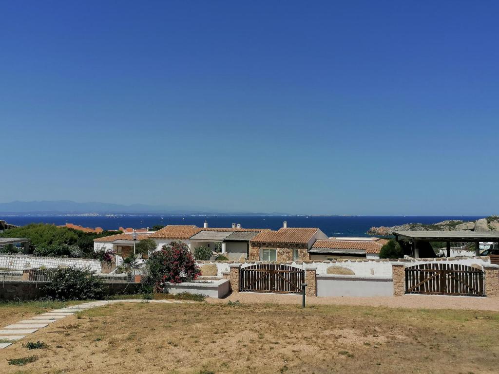 a group of houses with the ocean in the background at Porto Quadro Villa's in Santa Teresa Gallura
