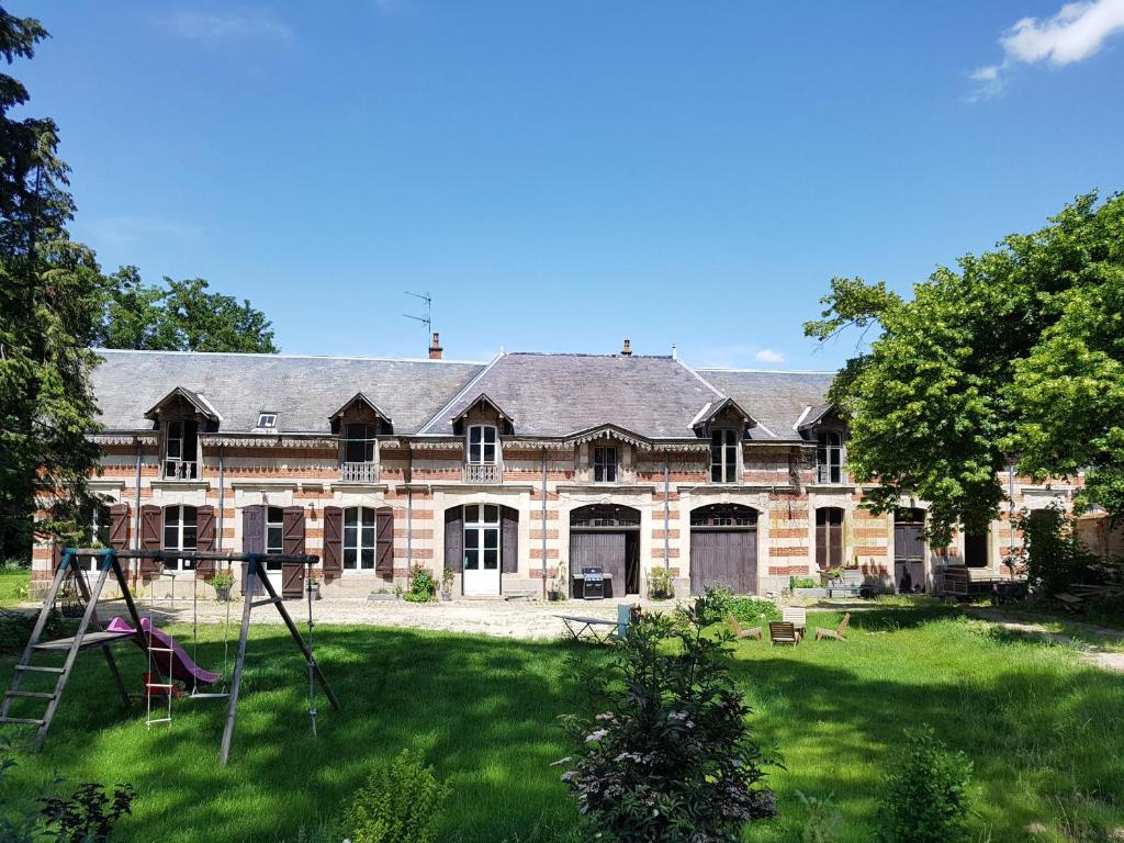 Villers-Allerand的住宿－La Bastide Champenoise - Chambres d'hôtes，一座大型砖砌建筑,在庭院里设有一个游乐场