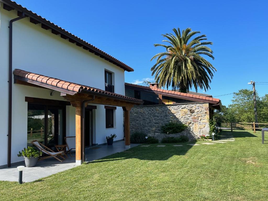 uma vista para uma casa com uma palmeira ao fundo em Casa Rural Mazarredonda em San Pantaleón de Aras