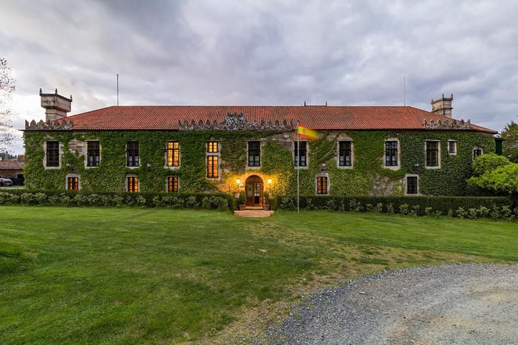 duży zielony budynek z dużym dziedzińcem w obiekcie Pazo de Brandeso & Country Club w mieście Arzúa