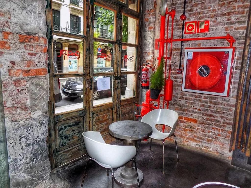 a bathroom with a sink, toilet and window at Poshtel Bilbao - Premium Hostel in Bilbao