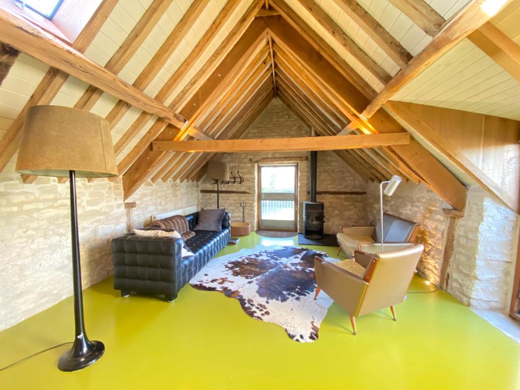 a living room with a couch and a lamp in a attic at The Hayloft in Stonehouse