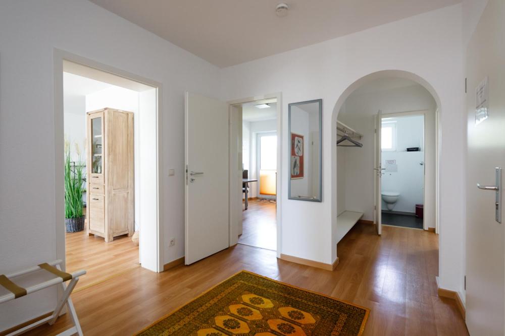 an empty living room with white walls and wood floors at Ferienwohnung Morillenhang in Aachen