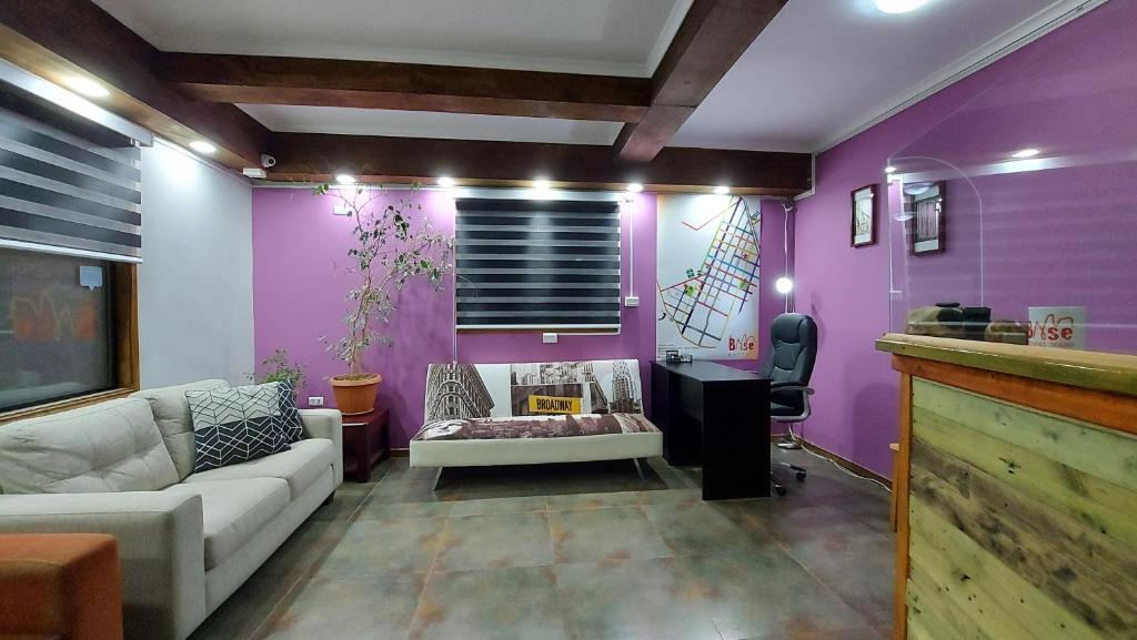 a living room with a couch and purple walls at Hostal La Base in Puerto Natales