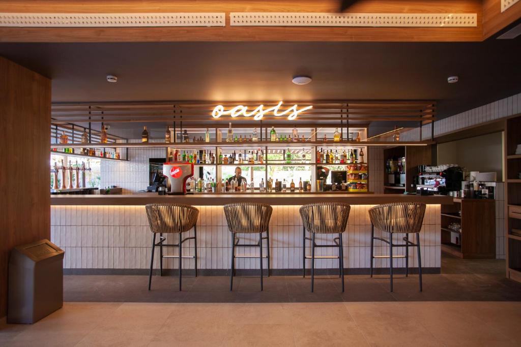 a bar with four chairs in front of a counter at Hotel Primavera Park in Benidorm