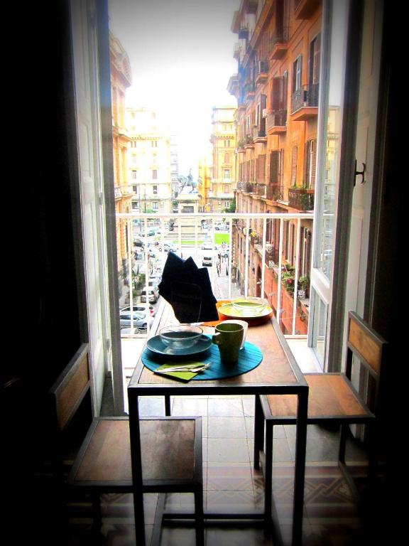 a table with two plates and a cup on a window at Napul'art in Naples