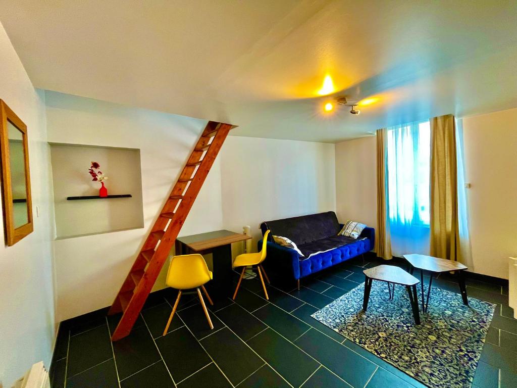een woonkamer met een blauwe bank en een trap bij Grand studio avec mezzanine in Orléans
