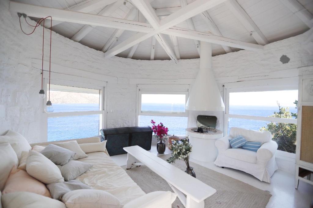 a living room with a large white couch and chairs at Villa Aiolos: above the sea, within Agios Nikolaos in Agios Nikolaos