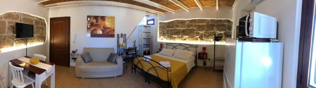 um quarto com uma cama, um sofá e uma mesa em Ninfa Alghero em Alghero
