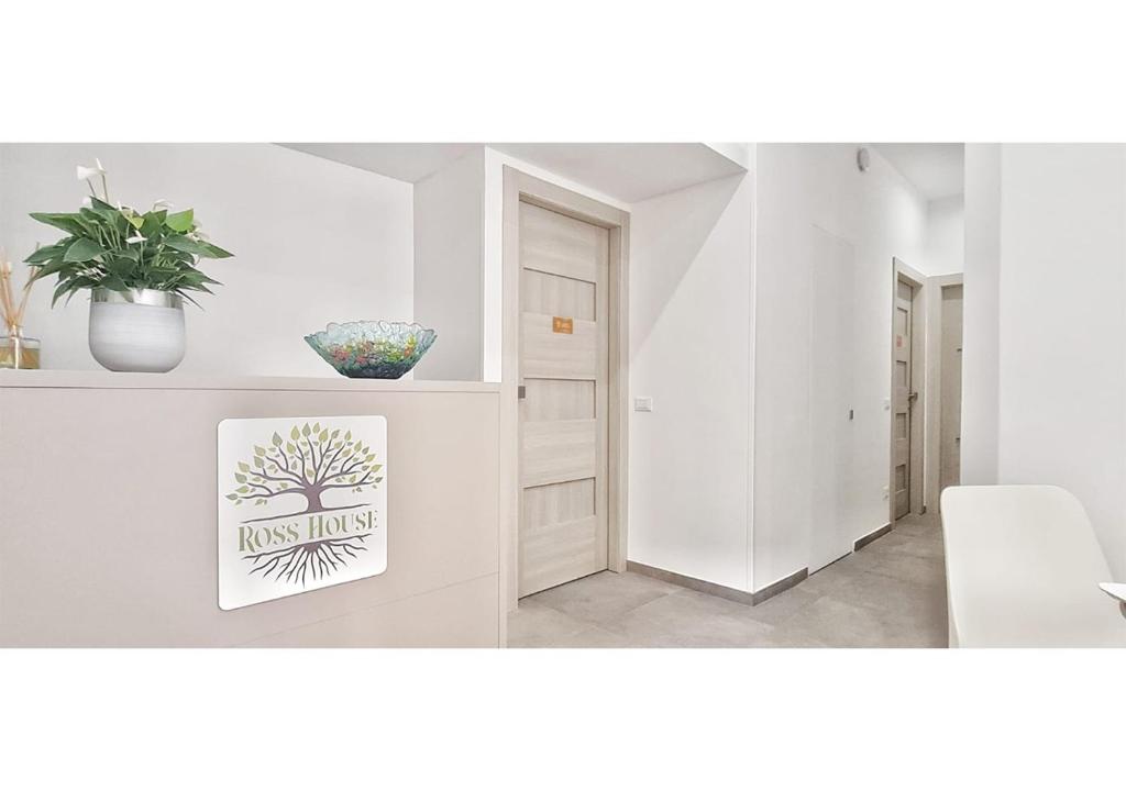 ein weißes Wohnzimmer mit einer Pflanze und einem Bild in der Unterkunft RossHouse in Sorrent