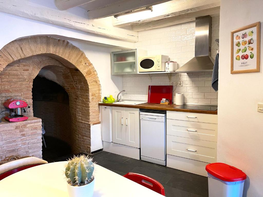 a kitchen with a brick oven with a table and a counter at Los Cuatro Cantones - Con BARBACOA in Ariza