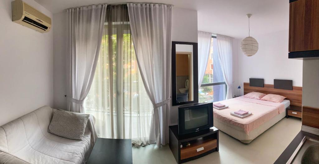 - une chambre avec un lit, une télévision et un canapé dans l'établissement Rainbow 3 Apartment-studio 223, à Sunny Beach