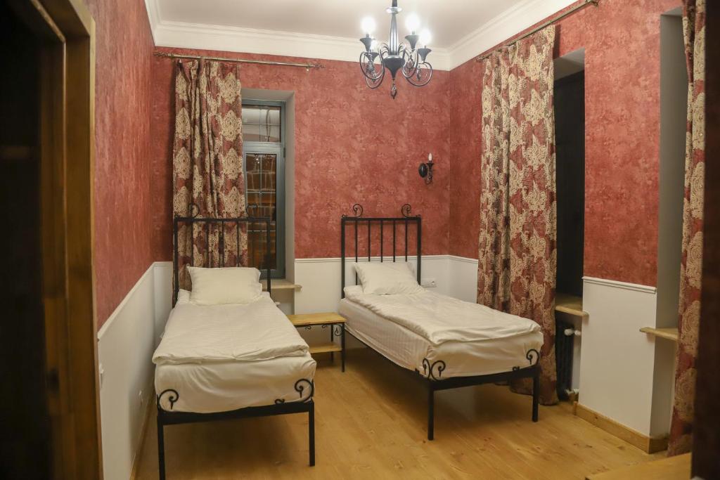 2 letti in una camera con pareti rosse di Nur Guest House a Gyumri