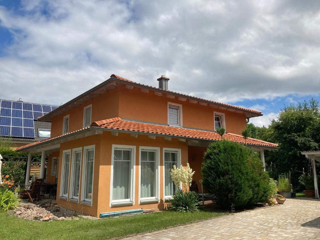 una pequeña casa naranja frente a un edificio en Villa Toskana Wohnung 1 en Wackersdorf