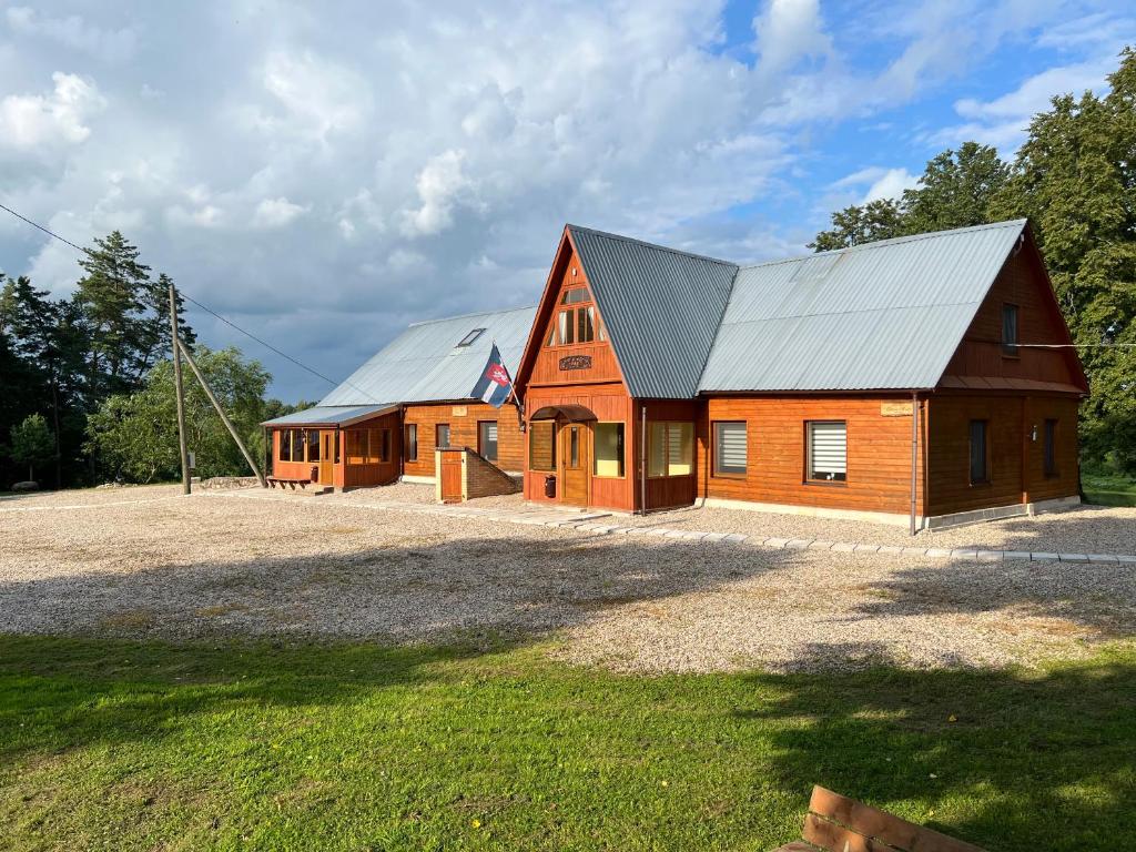 a large wooden house with a metal roof at Guest house Elernes Muiža in Daugavpils