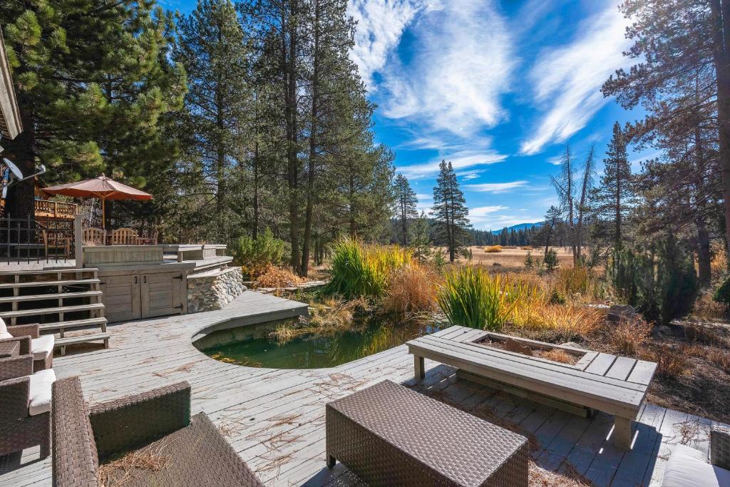 a patio with a pond and benches and trees at Bennett Flat Adventure in Truckee
