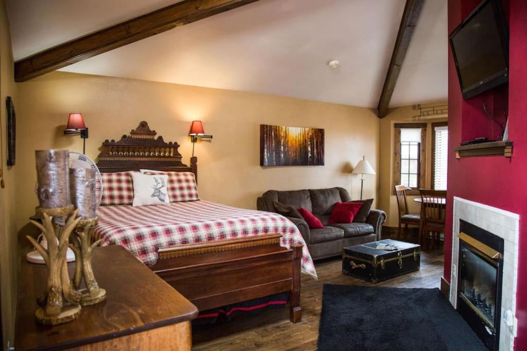 a bedroom with a bed and a couch in a room at Sundance Suite, 1 Bedroom with fireplace Dogs OK in Estes Park