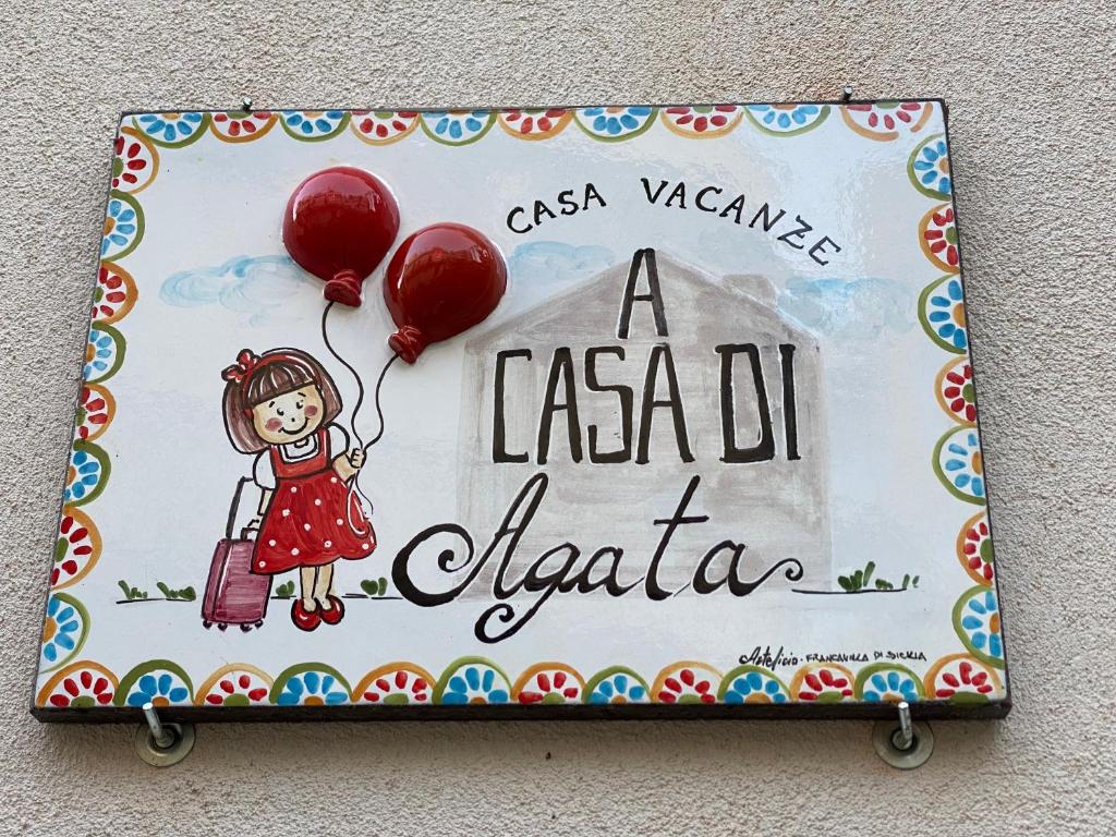 a sign for a casa de acacia with red balloons at A Casa di Agata in Taormina