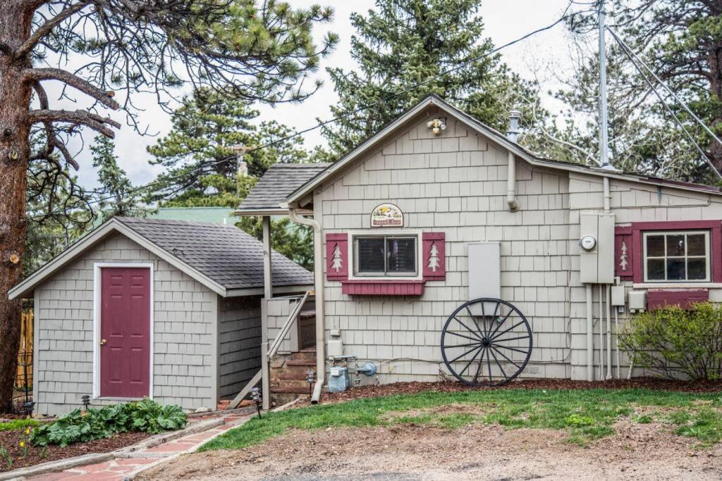 a white house with a red door at Prospect Cabin, Cozy 1-bedroom cabin with kitchen Dogs OK in Estes Park