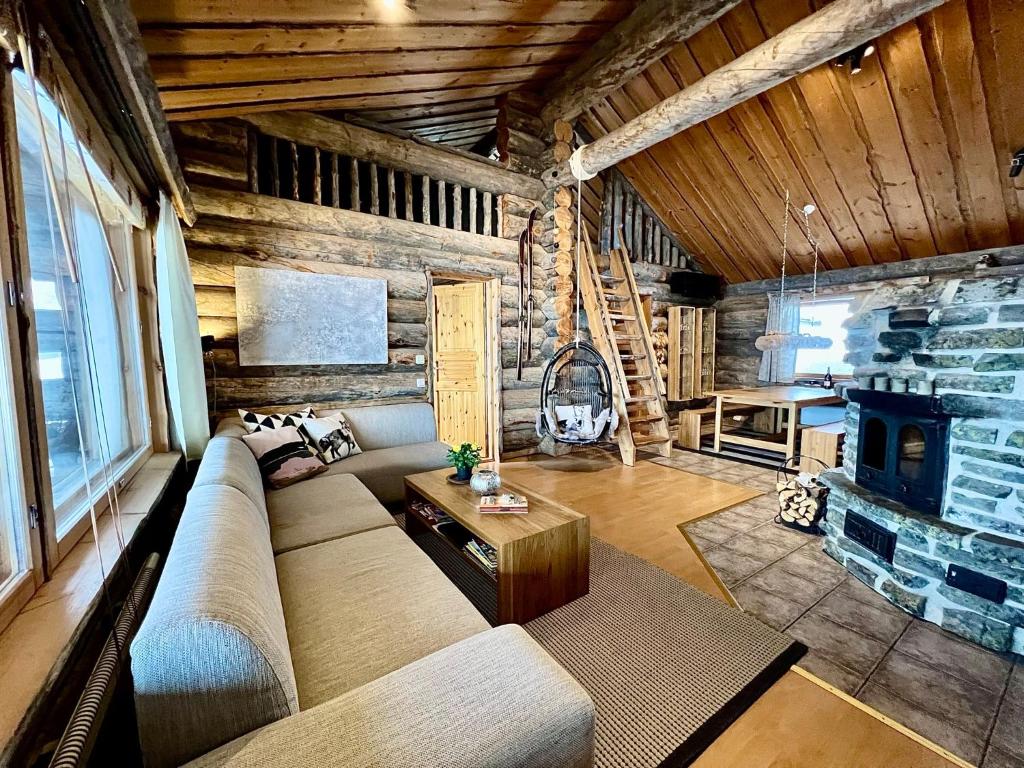 een woonkamer met een bank en een open haard bij Villa Saarua by the Slopes Ski in, Family & Bike Park, hike trails, National Park, WiFi - Lapland Villas in Ruka