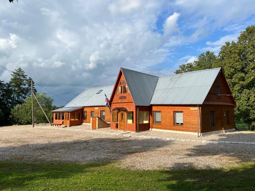 a large wooden house with a metal roof at Guest house Elernes Muiža in Daugavpils