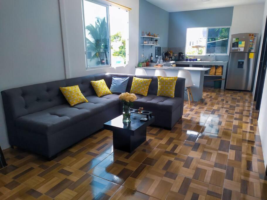 a living room with a couch and a table at Departamento cómodo vacacional in Manta